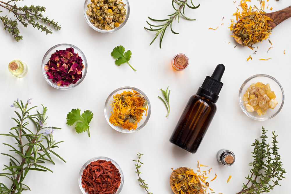 Bottles of essential oil with herbs and flowers on a white background naturopathic medicine in north york