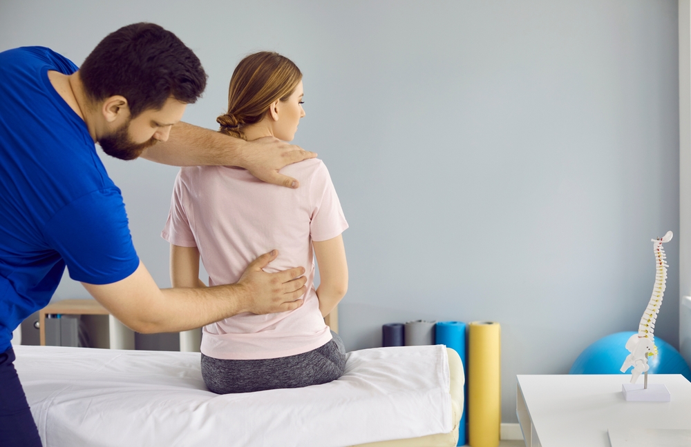 Professional,Physiotherapist,Doctor,Treats,Young,Woman's,Spine,Pain,In,Modern
